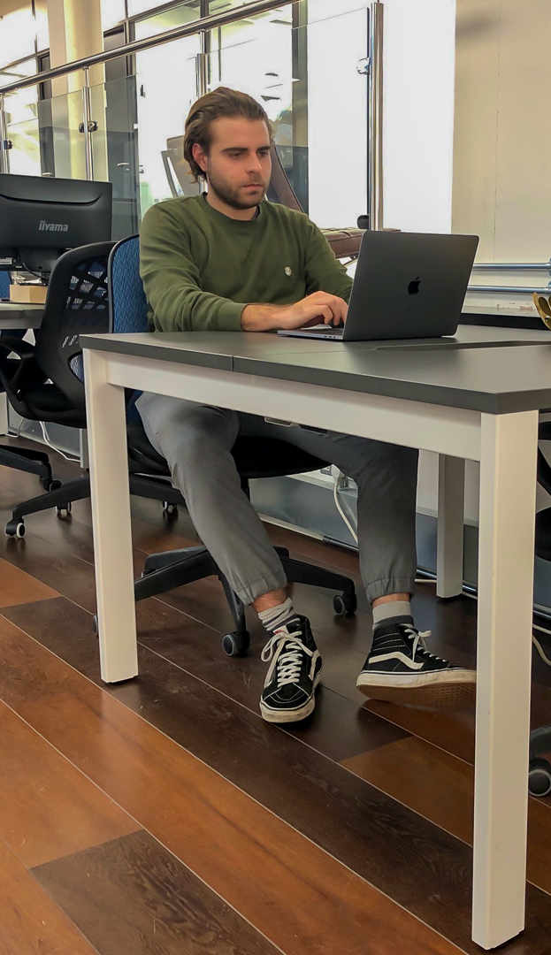 Person sitting at a desk, working on their laptop